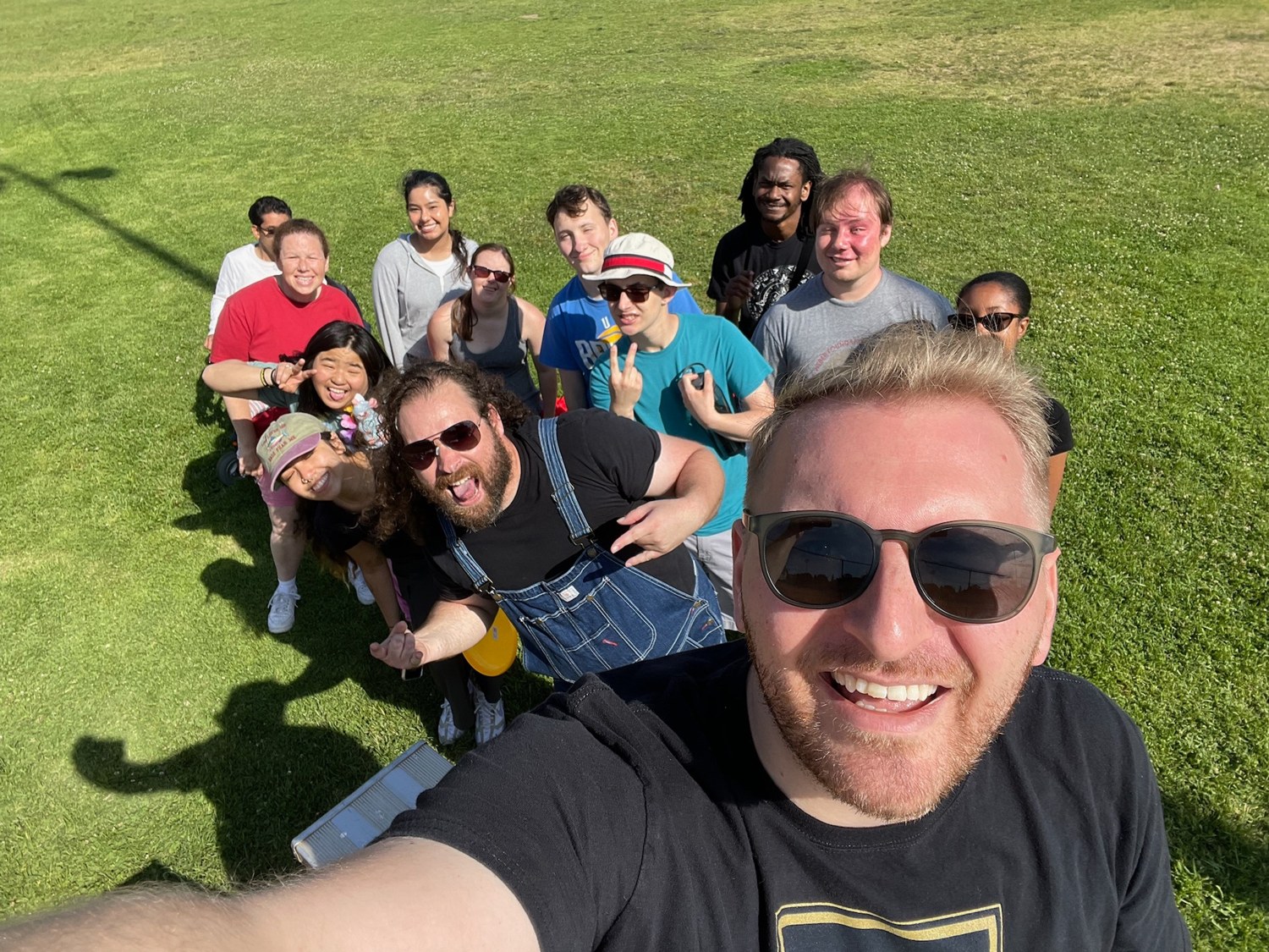 A group posing together on a grassy lawn